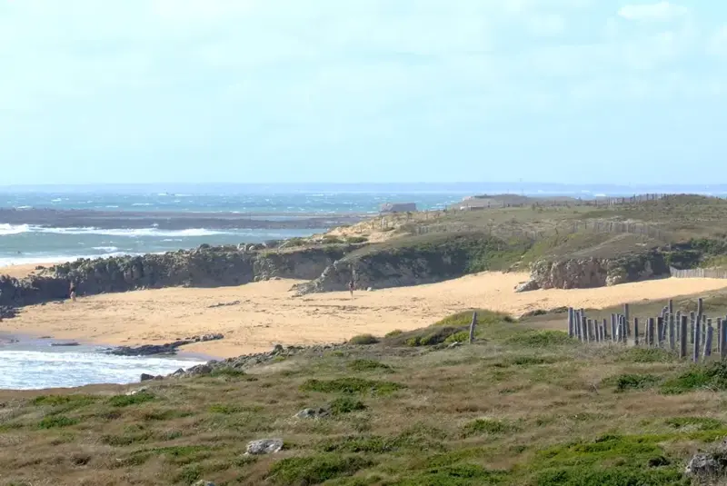 Mehrere Leute wandern auf Steg am Meer entlang
