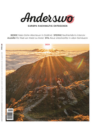 Anderswo-Titel-2024 Eine Frau sitzt bei Sonnenaufgang auf einem Berggipfel